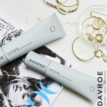 Two Davroe hair care products on a magazine with jewelry in the background